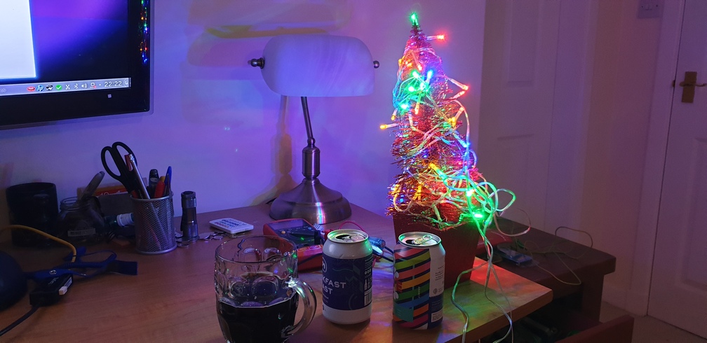 A small Christmas on a desk with some beer.